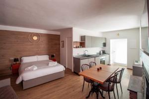 a bedroom with a bed and a table and a kitchen at Porto 03 in Albosaggia