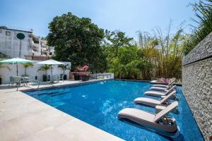 a swimming pool with lounge chairs next to a building at Ocean-View Backdrop and Private BBQ, Upscale 2 BR in Puerto Vallarta