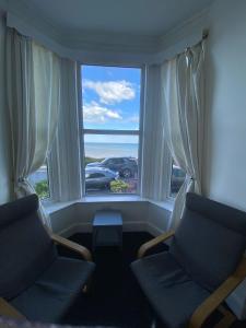 a living room with two chairs and a large window at Farina No2, Sea view apartment sleeping 4 guests in Bridlington