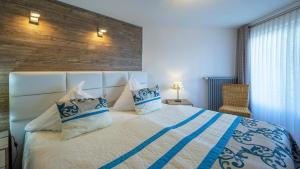a bedroom with a large bed with blue and white pillows at Ferienwohnung Maarpanorama in Schalkenmehren am See in Schalkenmehren