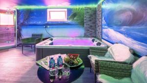 a room with a tub with a table with a bowl of fruit at Ferienwohnung Maarpanorama in Schalkenmehren am See in Schalkenmehren