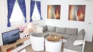 Una sala de estar con un sofá y un televisor. en Ferienwohnung Vulkaneifel, en Schalkenmehren