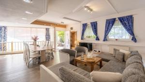 una sala de estar con un sofá y una mesa en Ferienwohnung Vulkaneifel, en Schalkenmehren