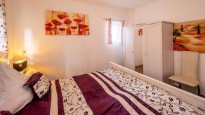 Un dormitorio con una cama y un cuadro en la pared. en Ferienwohnung Vulkaneifel, en Schalkenmehren
