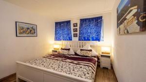 Un pequeño dormitorio con una cama con cortinas azules en Ferienwohnung Vulkaneifel, en Schalkenmehren