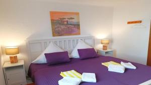 a bedroom with a purple bed with two purple pillows at Ferienwohnung Seeblick II in Schalkenmehren