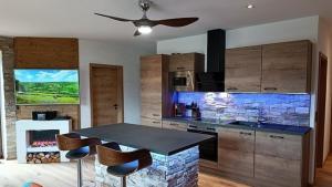 a kitchen with a table and a stone fireplace at Ferienwohnung Luxus 5 Sterne Ferienwohnung - Chalet Seenähe in Schalkenmehren
