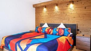 a bedroom with a colorful bed with a wooden wall at Ferienwohnung Luxus 5 Sterne Ferienwohnung - Chalet Seenähe in Schalkenmehren +24 photos