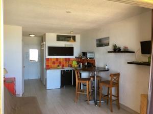 a kitchen with a table and chairs in a room at Seafront studio in Algajola
