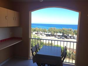 a dining room with a table and a view of the ocean at Seafront studio in Algajola +4 photos