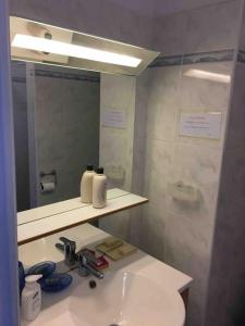 a bathroom with a sink and a mirror at Seafront studio in Algajola