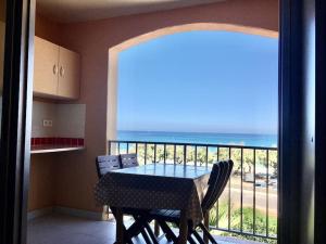 a table and chairs in a room with a view of the ocean at Seafront studio in Algajola