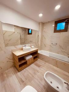 une salle de bain avec un lavabo, des toilettes et une baignoire dans l'établissement Apart Altos Del Nahuel, à San Carlos de Bariloche