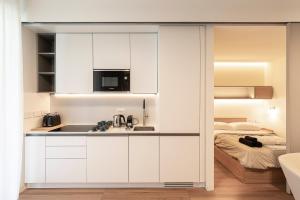 ミラノにあるTorre Milano Luxury Suite Gym-Pool&Rooftopのキッチン(白いキャビネット、ベッド1台付)