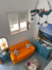an orange couch in a living room with a window at La Bella Annacapri in Anacapri