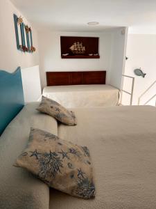 a bedroom with two beds and a couch with pillows at La Bella Annacapri in Anacapri