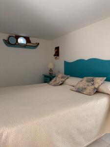 a bedroom with a large bed with a blue headboard at La Bella Annacapri in Anacapri