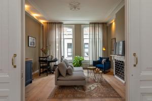 a living room with a couch and a chair at Het Herenhuis Middelburg in Middelburg +43 photos
