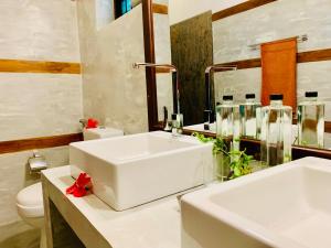 ein Badezimmer mit einem weißen Waschbecken und einer Toilette in der Unterkunft Suite Lanka in Hikkaduwa