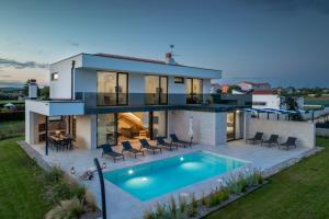 a house with a swimming pool in the backyard at Villa Celi whit heating pool Fazana Pula in Fažana