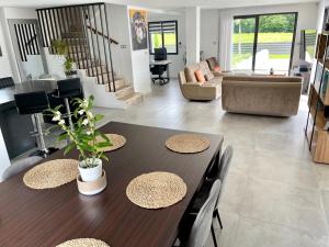 a living room with two tables and a couch at Villa familiale & plongeons in Sainte-Eulalie