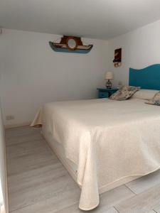 a bedroom with a white bed and a blue table at La Bella Annacapri in Anacapri