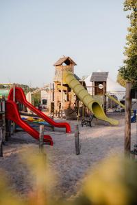 een speeltuin met een glijbaan voor een gebouw bij ASILI DELUXE - Zebra in Lichtaart