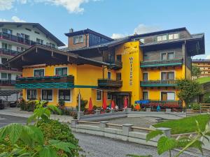 żółty budynek z parasolami przed nim w obiekcie Hotel Garni Wolfgang w Saalbach Hinterglemm