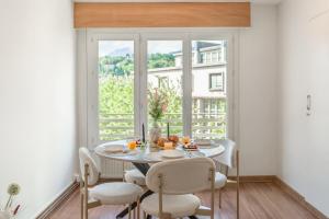 a dining room with a table and chairs and a window at Appartement unique - Centre ville in Chambéry
