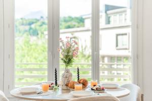 a table with a plate of food on a table with a window at Appartement unique - Centre ville in Chambéry