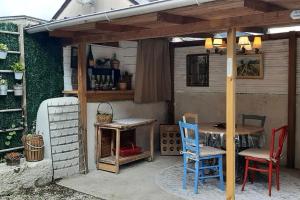 un patio con mesa y sillas bajo una pérgola en La Bergerie d'Annie, en Véretz