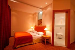 a hotel room with a bed and a toilet at Amber SPA Boutique Hotel in Jūrmala