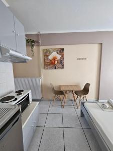 a kitchen with a table and two chairs in it at Platsa Studios in Megás Limniónas