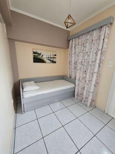 a small room with a bed and a curtain at Platsa Studios in Megás Limniónas