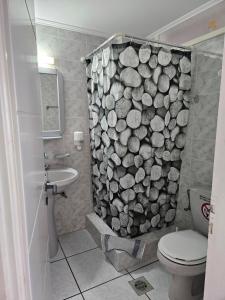 a bathroom with a shower curtain made out of logs at Platsa Studios in Megás Limniónas