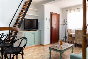 Una sala de estar con televisión, mesa y sillas. en Colina del Mar, en Torremolinos