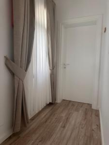 an empty room with a curtain and a door at Riviera Hotel-City Center in Vlorë