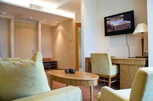 a living room with chairs and a table and a tv at Amber SPA Boutique Hotel in Jūrmala