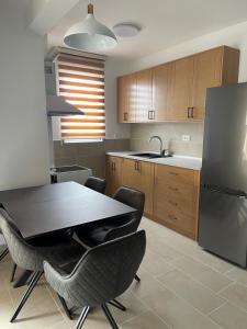 a kitchen with a table and chairs and a refrigerator at Apartment Tramontana - Konoba More in Pržno