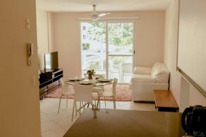 una sala de estar con una mesa y un sofá en Residencial Porto da Brava - NDI001, en Florianópolis