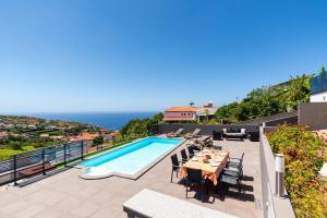 a patio with a table and a swimming pool at Casa Antonette, Lovely house with a pool in Calheta