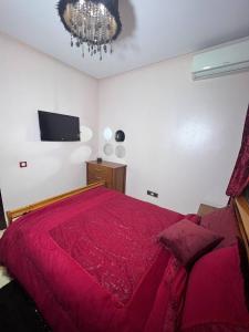 a bedroom with a large red bed with a chandelier at Tanger mlbta in Tangier