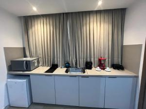 a kitchen with a counter with a microwave and a sink at Flat Maravilhoso na Praia de Cabo Branco in João Pessoa +11 photos