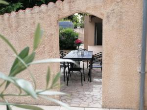 a patio with a table and chairs in a wall at La Maison de Joséphine 4 chambres in Pierrelatte