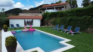 a swimming pool with inflatables and chairs in a yard at Retiro do Mestre in Mondim de Basto