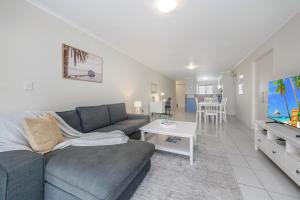 a living room with a couch and a tv at City Love Affair On Stanley in Townsville