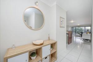 a bathroom with a mirror on a white wall at City Love Affair On Stanley in Townsville +16 photos