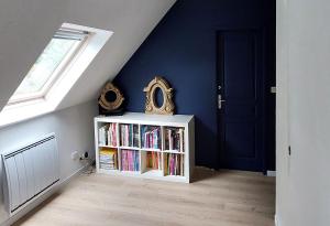 ein Zimmer mit einem Bücherregal mit Büchern und einem Fenster in der Unterkunft Maison mer et campagne in Pluvigner