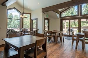 Un comedor con mesas y sillas y ventanas. en Snowcreek Condo 1516, en Sun Valley