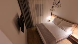 a bedroom with a bed with white sheets and pillows at Mouson Luxury Apartment in Kavala